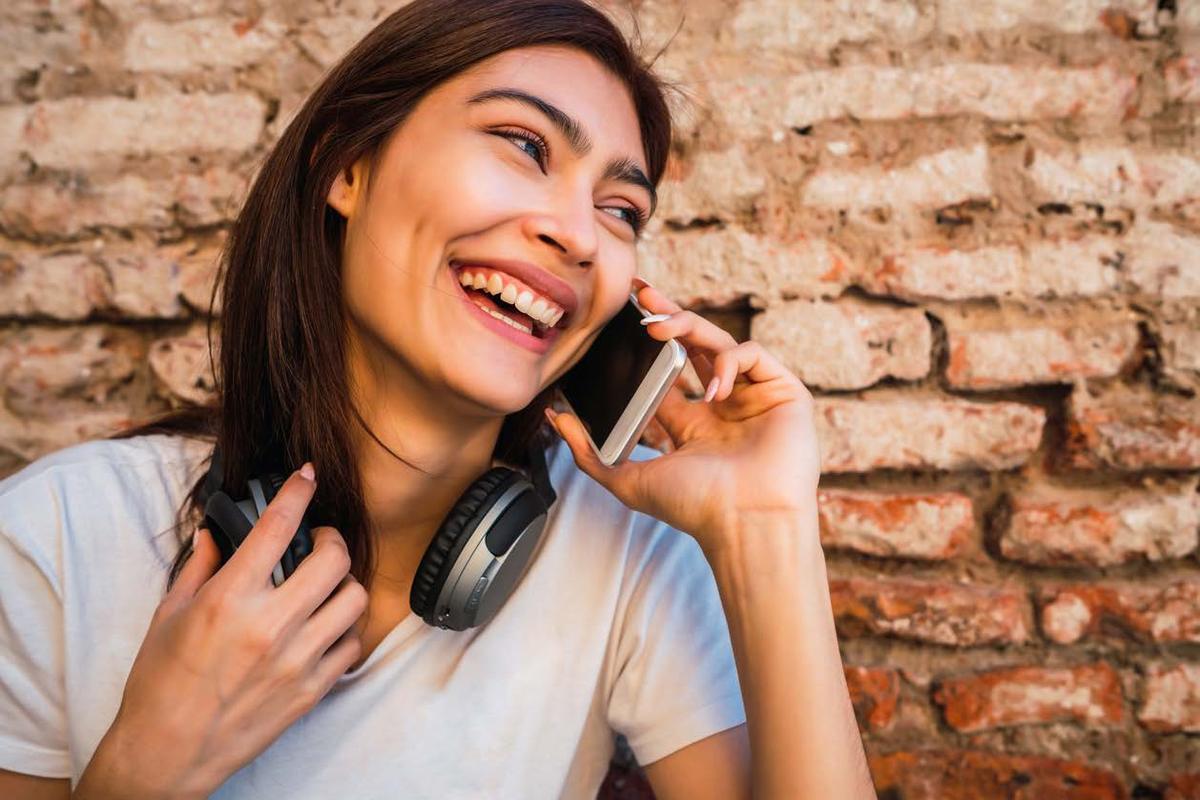 Tutora sorrindo enquanto liga para o seu pet